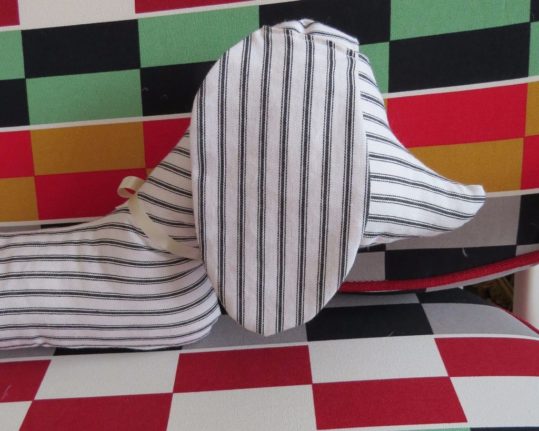 Dachshund Draft Excluder Scraps is inspired by a dachshund draft excluder my Granny had. I have updated him for the 21st century providing you with a friendly and practical dog companion that will stop the drafts under your door, but will also look cute perched atop a sofa, dresser, bed or mantelpiece. From the tip of his nose to his tail, Scraps measures 90cm. Scraps is made from fabrics that I use in my quilts, so he is 100% British designed and made.