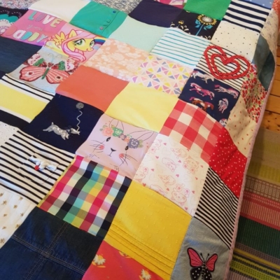Memory quilt stitched from daughter' clothes.